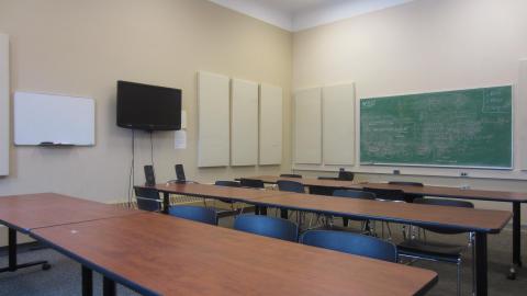"Image of Presentation Practice Room 2000 showing tables, screen, and blackboard"