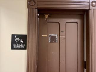 Door marked with a sign for all-gender restroom