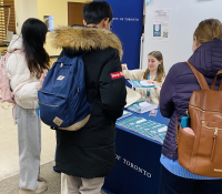 group of students receiving swag from an outreach table